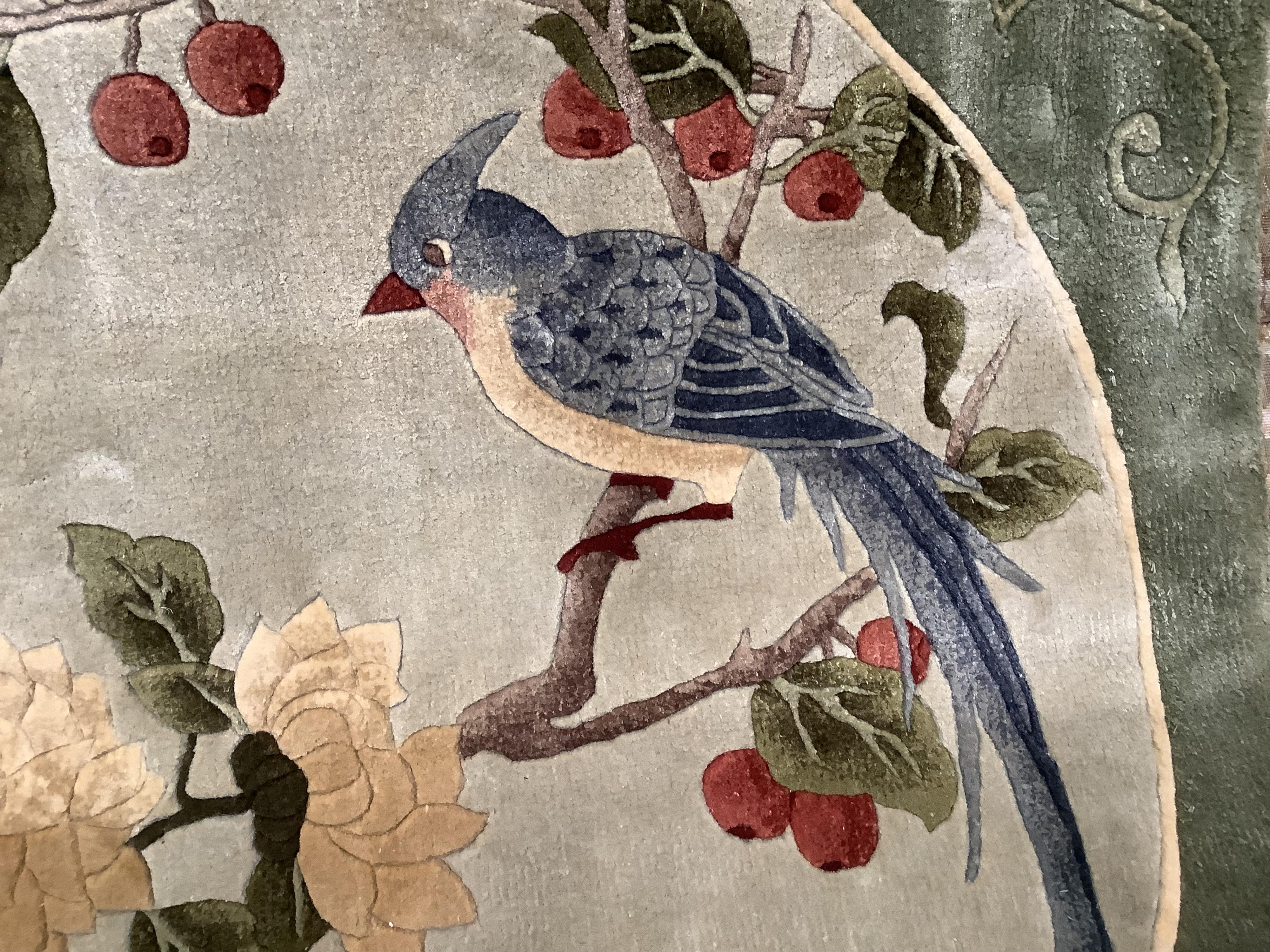 A Chinese washed and embossed panel depicting birds amongst prunus and cherries